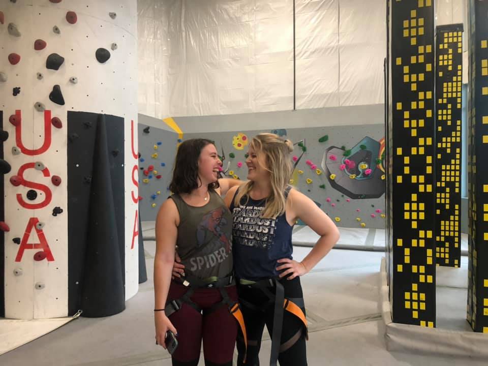 Marshall Early Career Organization members Susan Martinez, left, and Meagan Johnson bond during a 2019 group wall-climbing.