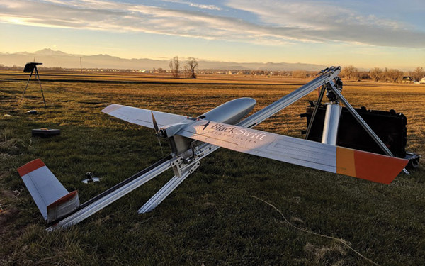 A small drone aircraft sitting on the ground.