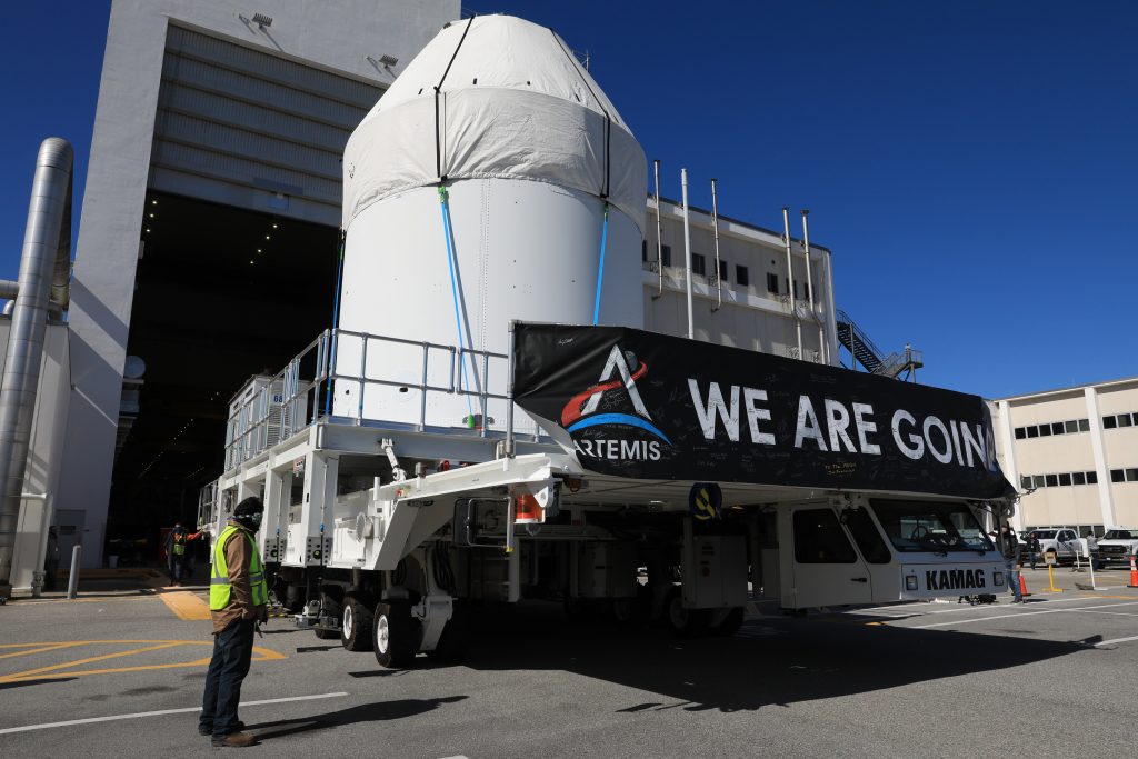 Orion is buttoned up and ready to march towards the Multi-Payload Processing Facility to begin ground processing by the Exploration Ground Systems and Jacobs teams ahead of the Artemis I launch. Shielded by a protective covering for transport, the spacecraft departs its home at the Neil Armstrong Operations and Checkout Building at NASA's Kennedy Space Center in Florida on Jan. 16, 2021.