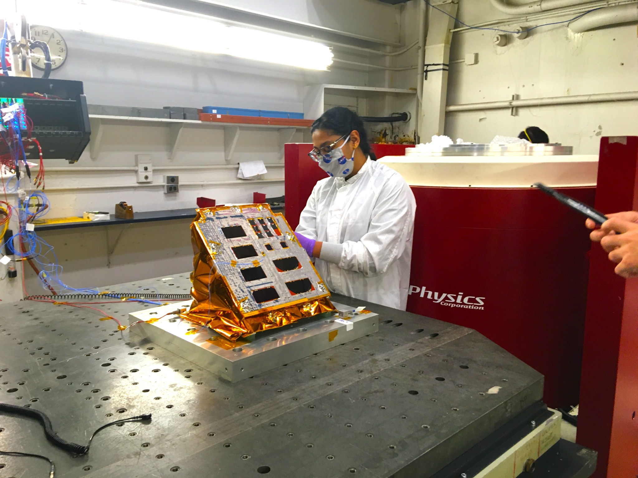 Female researcher in lab inspecting an experiment set up on a vibration table.