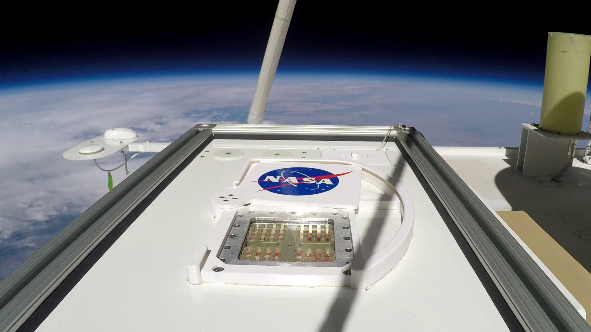 NASA experimental hardware carrying samples of bacteria is seen high above Earth