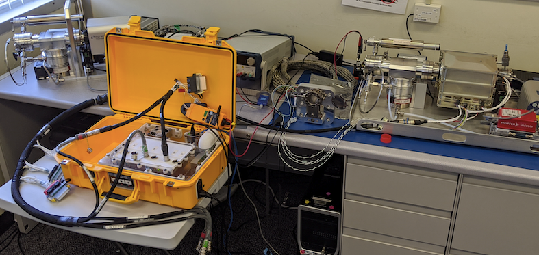 A yellow device on a table, connected to another instrument on a neighboring table.