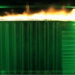 Plexiglass material glowing green with as flames are visible on top.