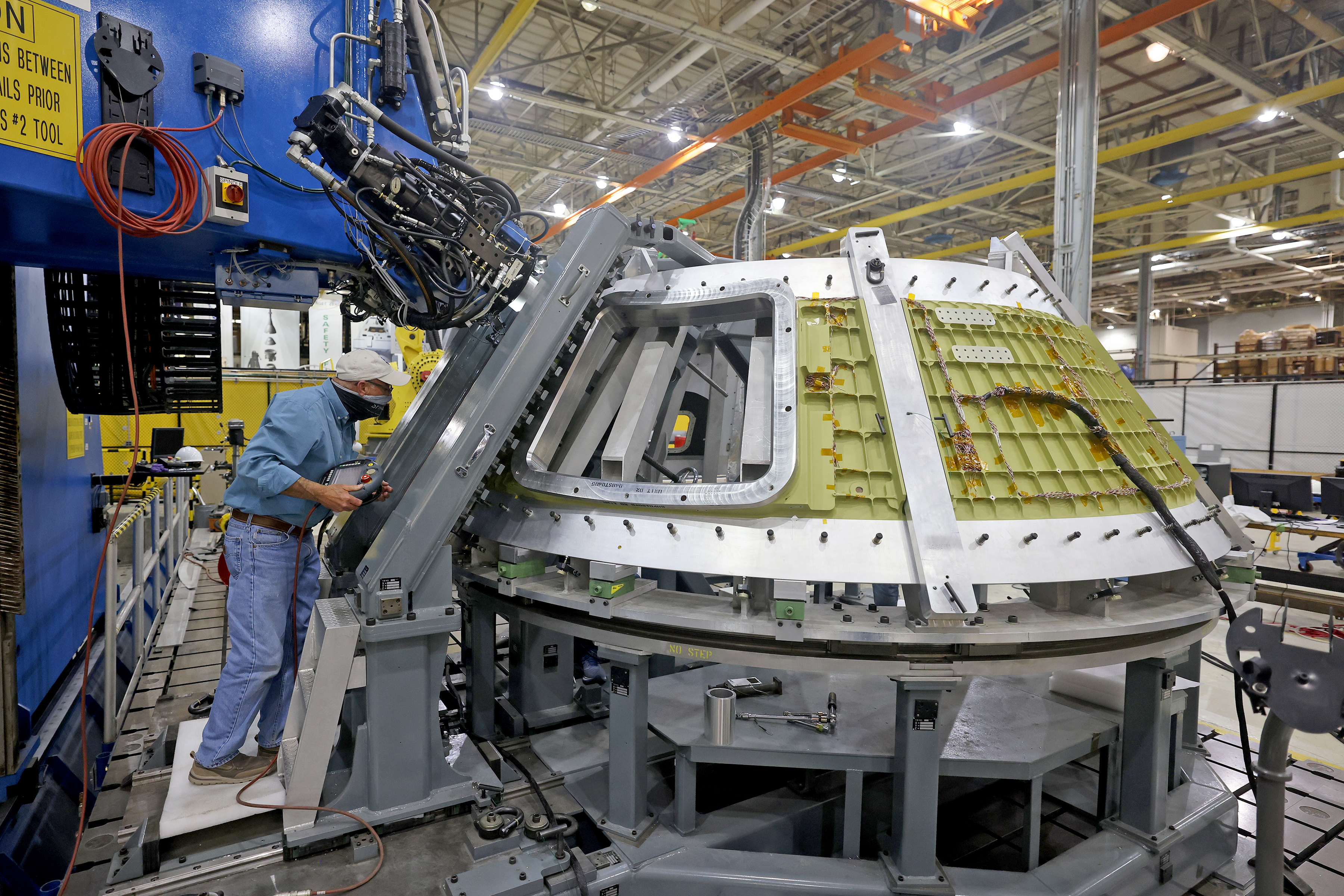 A technician views the Artemis III Orion spacecraft structure during welding activities