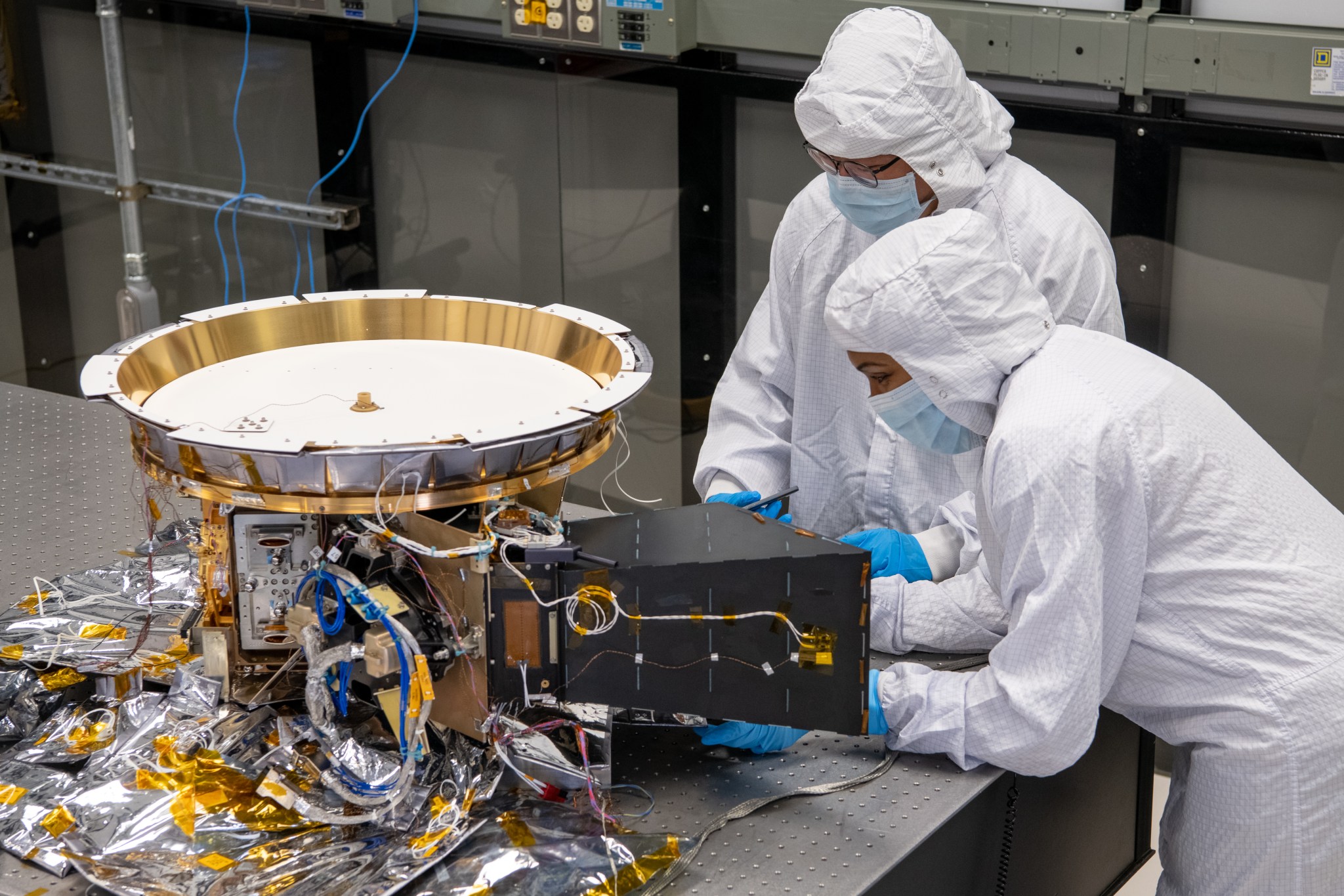 technicians in protective suits work on technology