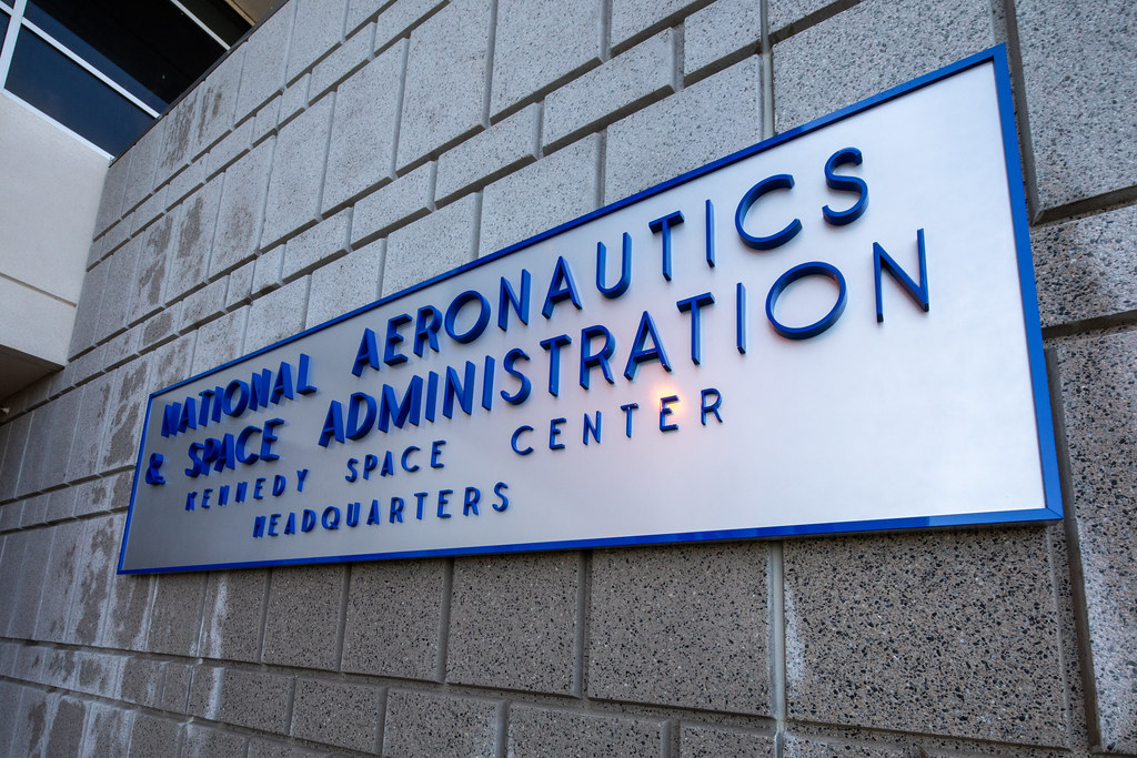 The refurbished sign from the original Headquarters building at NASA's Kennedy Space Center in Florida is installed by the main entrance of the new Central Campus Headquarters, Feb. 18, 2021.