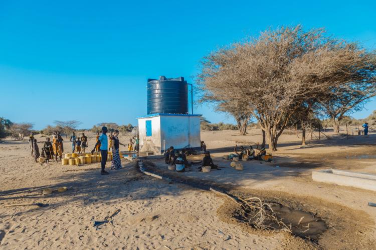 photo of people waiting at a water pump in Kenya