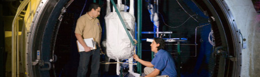 Thumbnail of two men working within the 15-foot chamber at Johnson Space Center