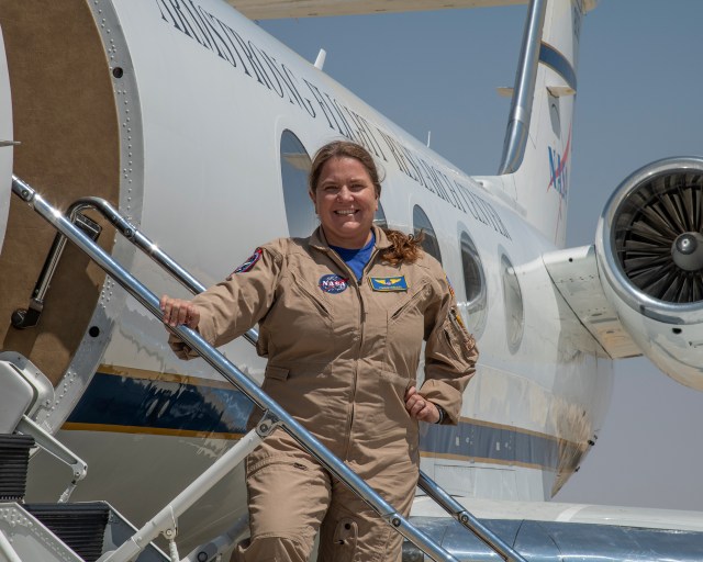 Photo of Pilot Carrie Worth, standing on aircraft stairs.