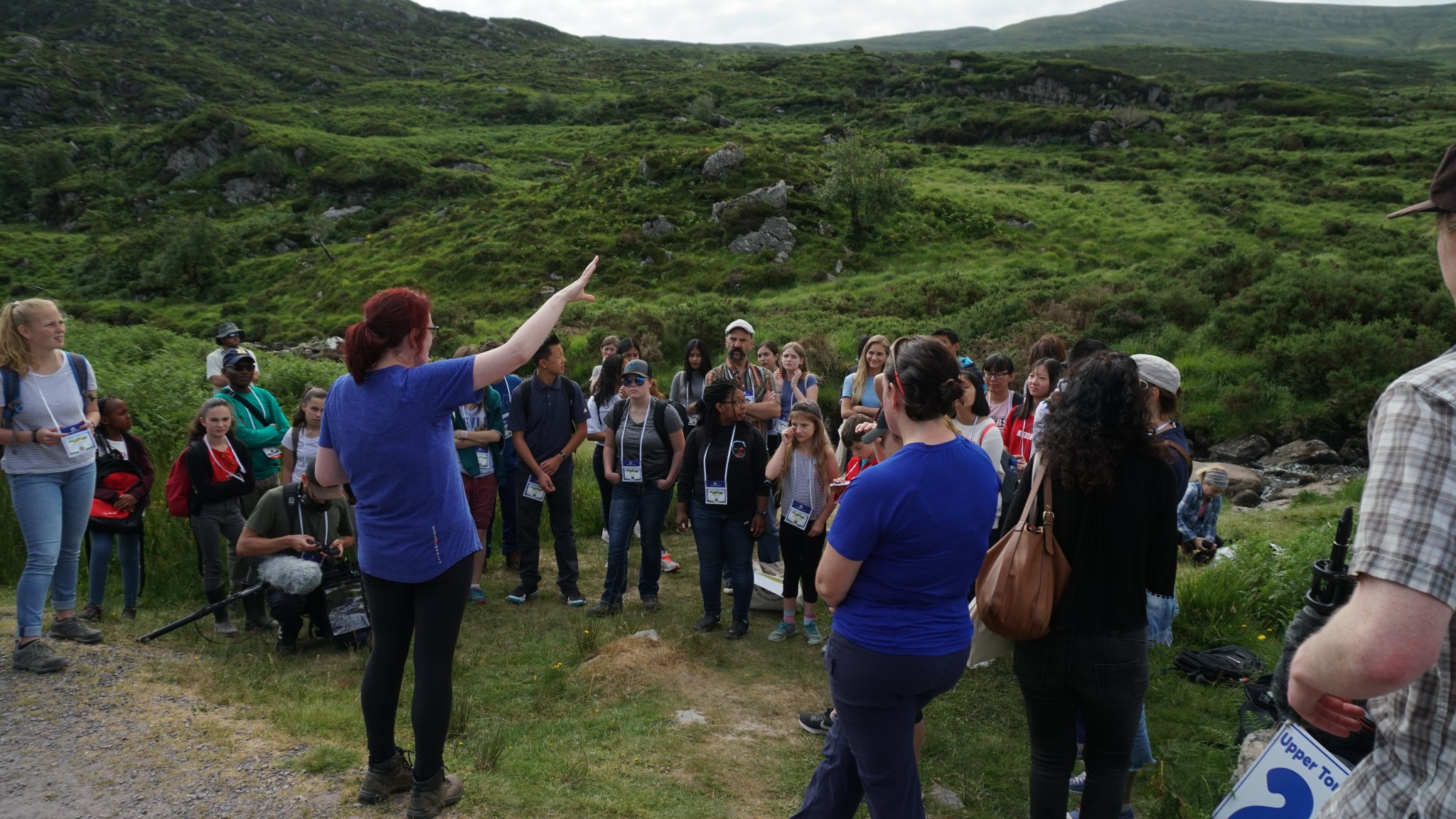 Student listen to a teach speak in rolling green hills in Killarney, Ireland.