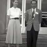 Woman and man posing for photograph on steps of Administration Building.