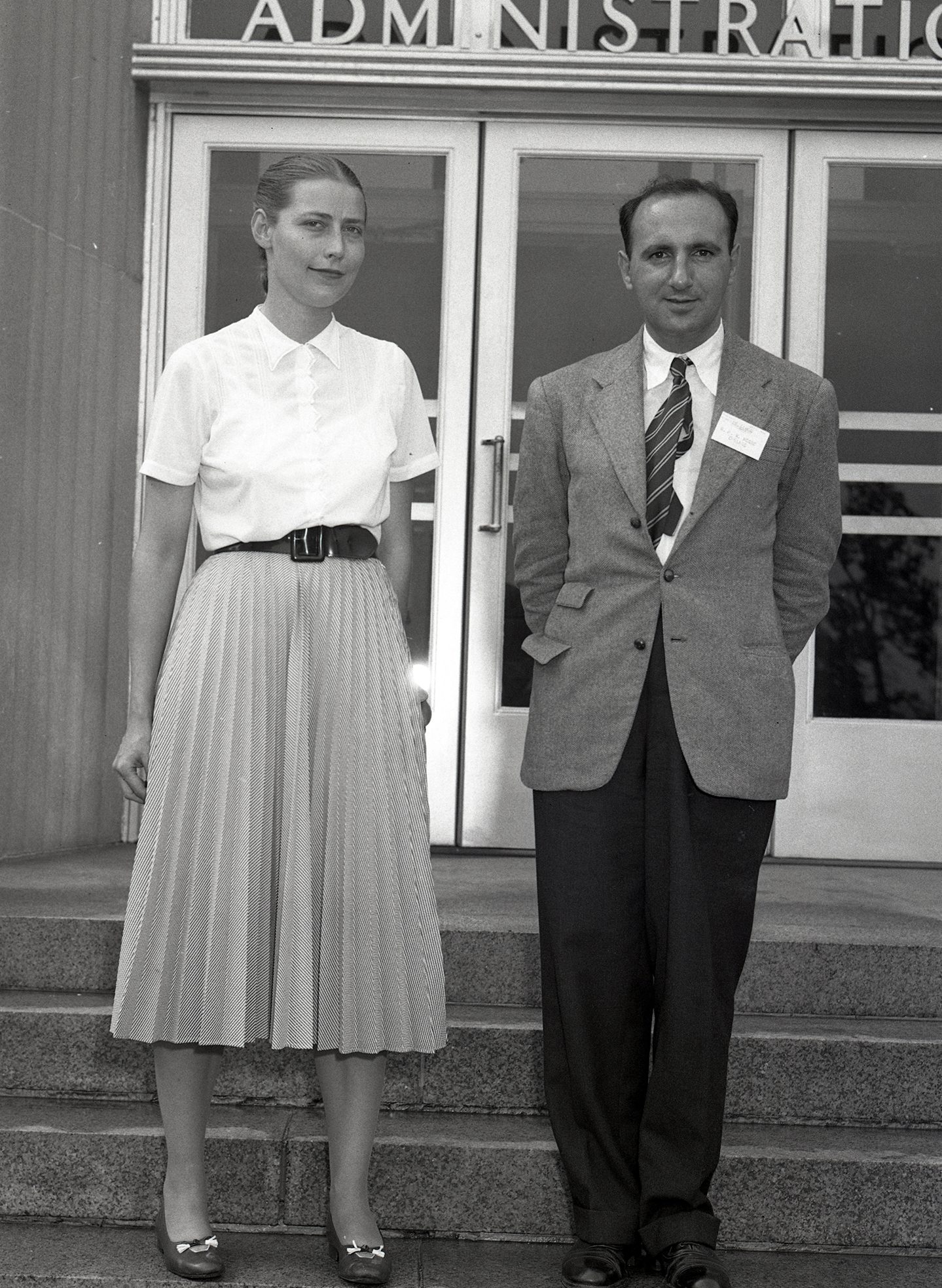 Woman and man posing for photograph on steps of Administration Building.