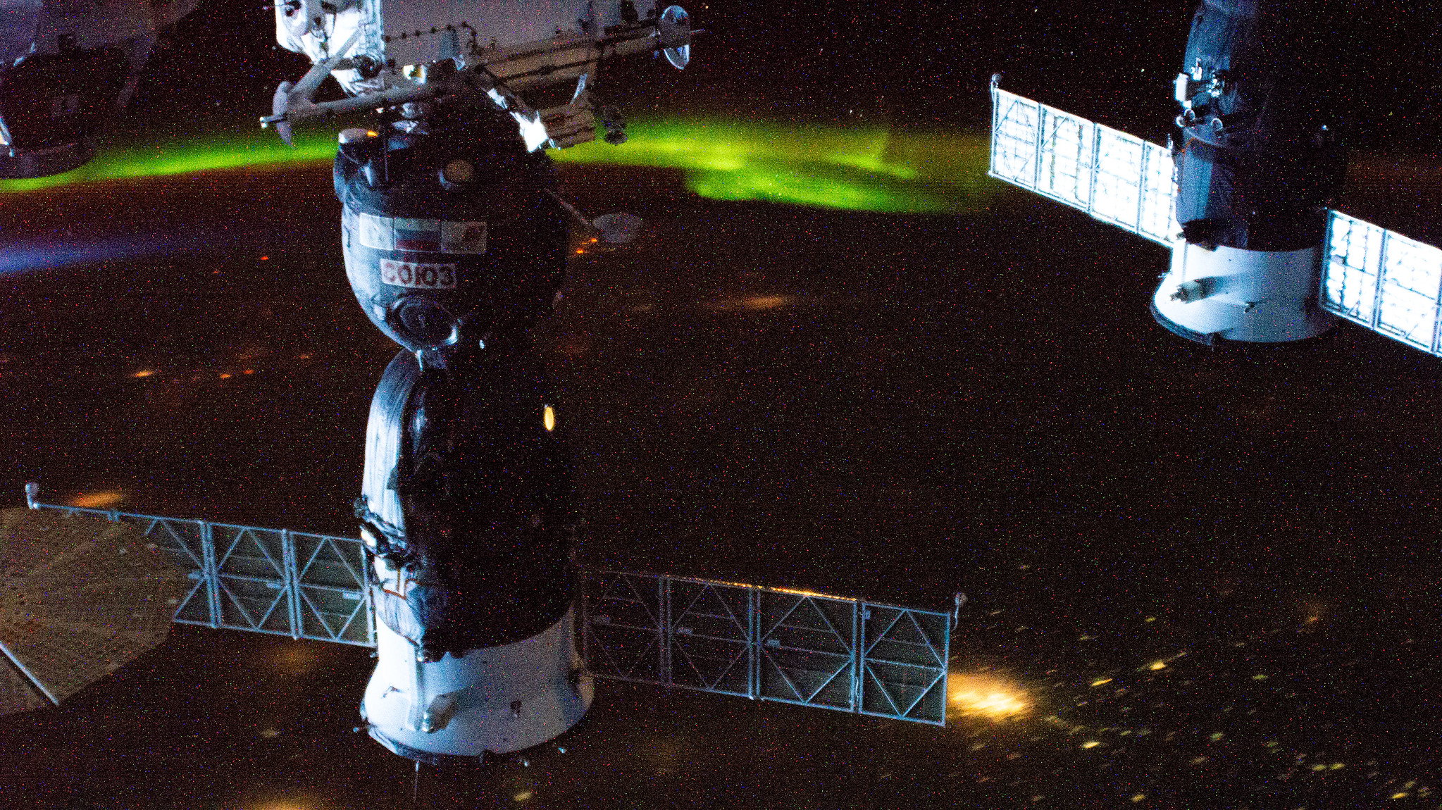 Two Russian spaceships (from left), the Soyuz MS-17 crew ship and the ISS Progress 77 cargo craft, are pictured docked to the International Space Station as it orbited 264 miles above Kazakhstan with an aurora glowing near the horizon.