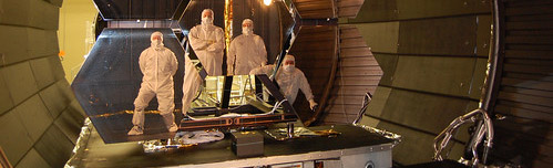 4 technicians standing with the James Webb Space Telescopes mirrors inside the XRCF.