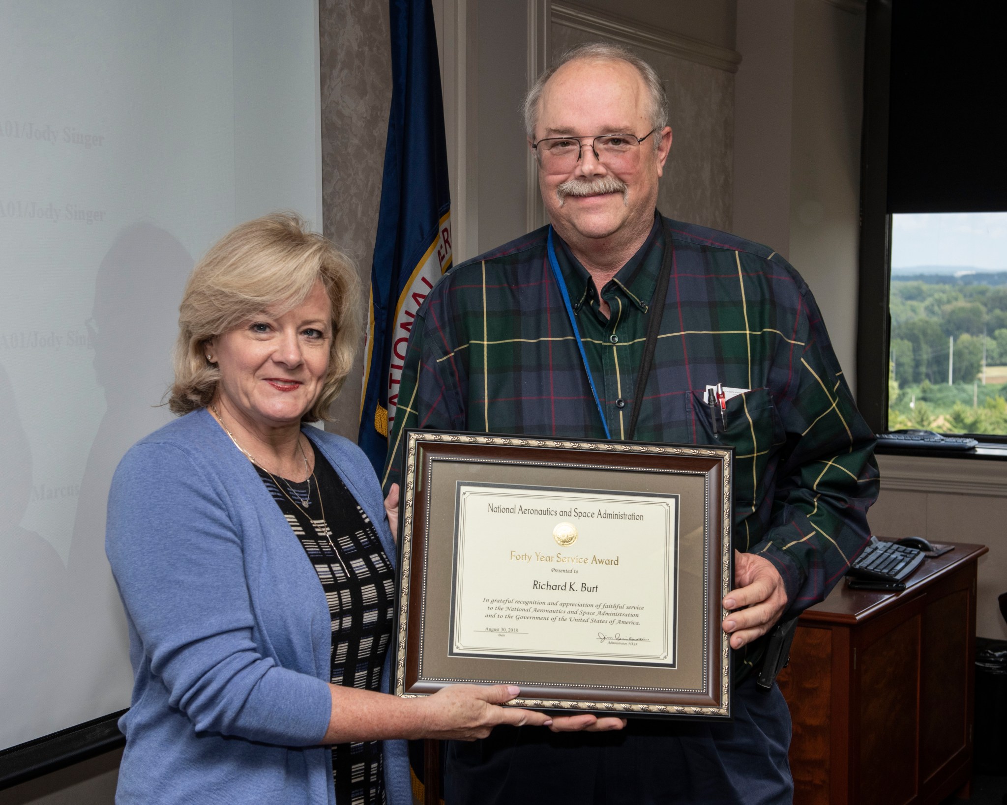 In 2018, Marshall Director Jody Singer, left, presents Rick Burt with a certificate reflecting his decades of service.