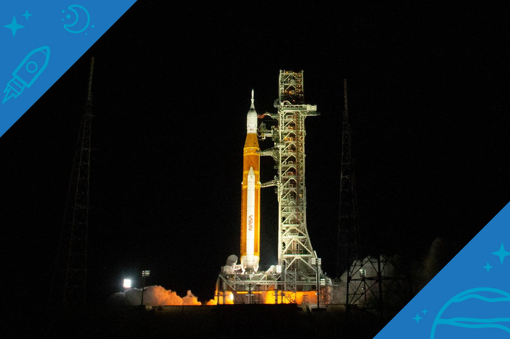 Artemis I sits on the launch pad at night, illuminated by lights from below