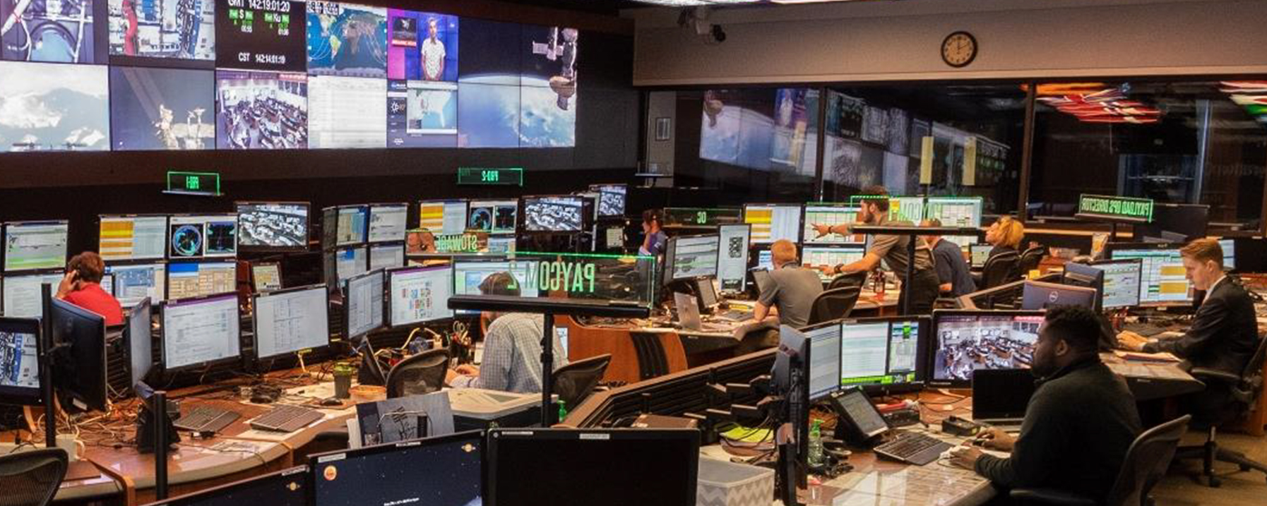 People sitting in room with screens