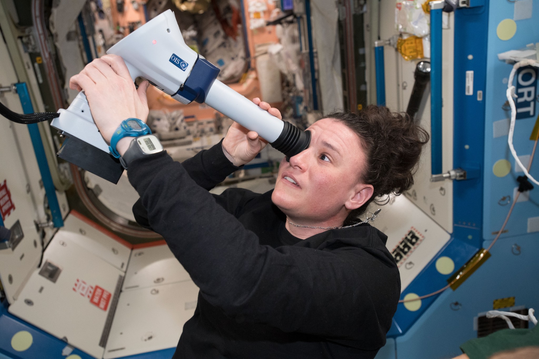 NASA astronaut Serena Auñón-Chancellor uses an instrument called a fundoscope to examine the interior structures of her eye 
