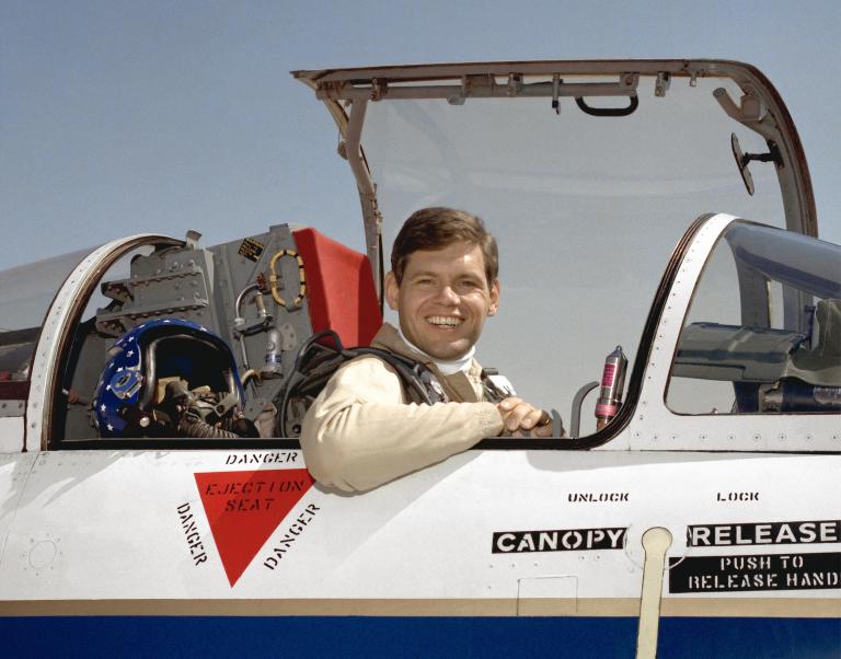 Man in aircraft, smiling.