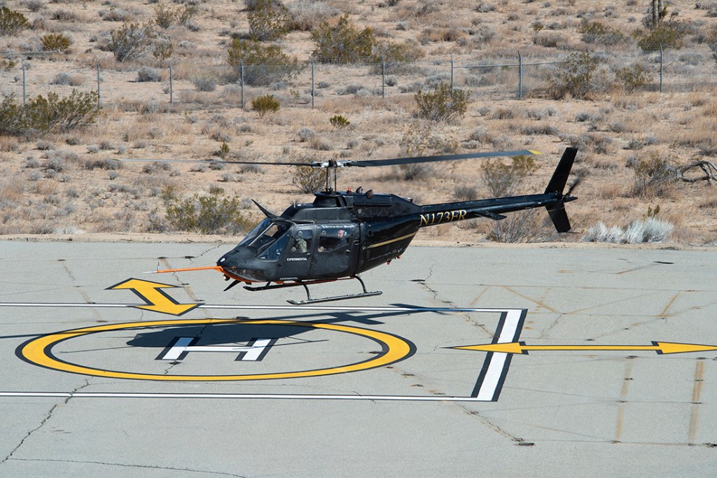 Flight Research Inc.?s Bell OH-58C Kiowa helicopter hovers over a helipad