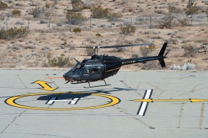 Flight Research Inc.?s Bell OH-58C Kiowa helicopter hovers over a helipad