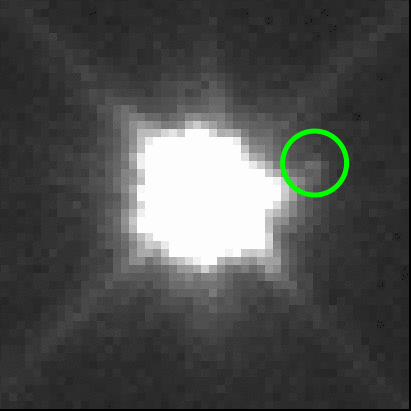bright-white glow of Eurybates, with diim Queta to one side, indicated with green circle