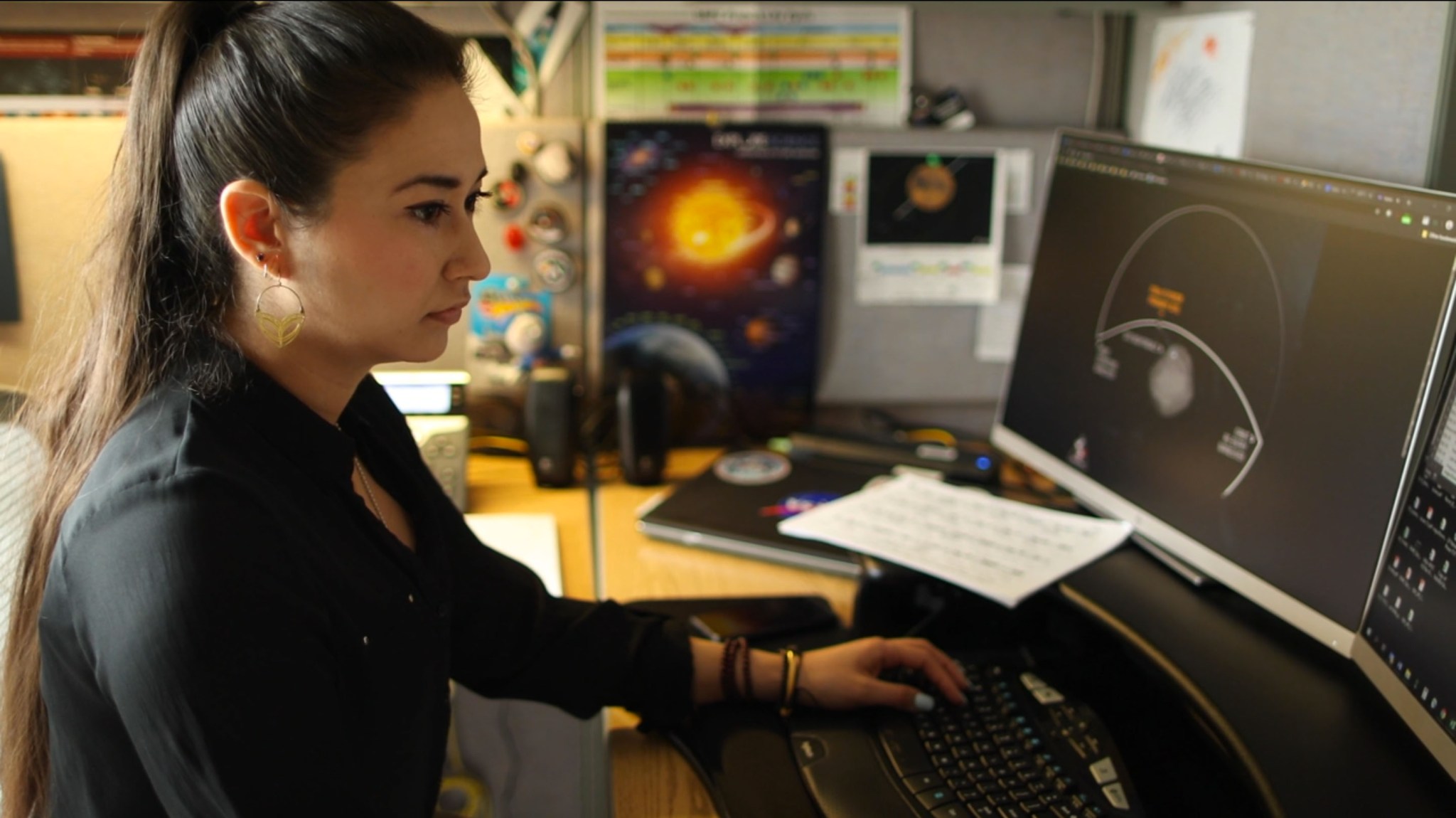 Nayi Castro at a desk looking at a computer monitor