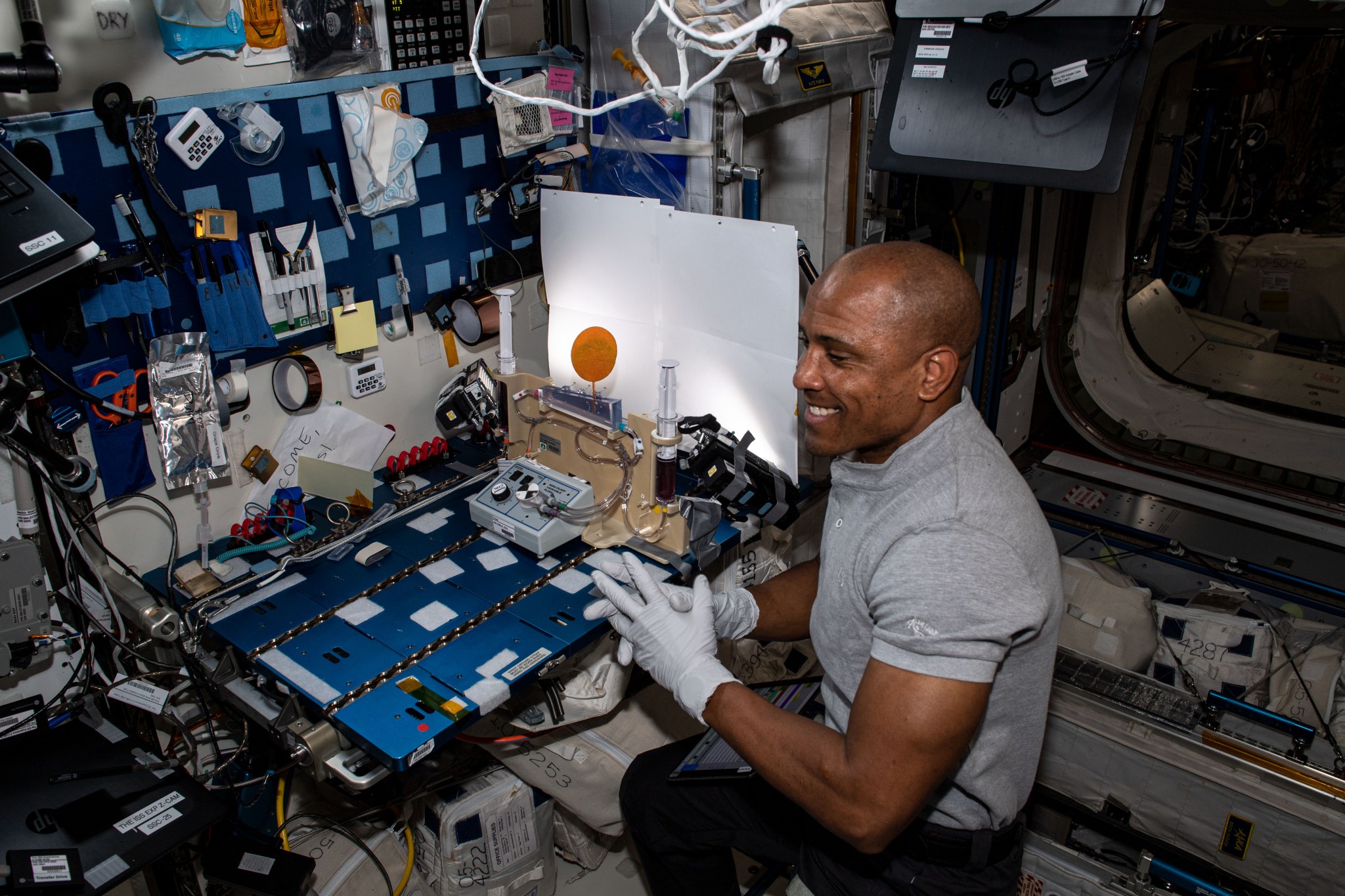 NASA astronaut and Expedition 64/65 Flight Engineer Victor Glover works on the Plant Water Management experiment.