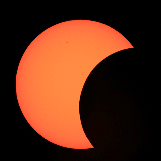 Showing the annular eclipse, the Moon moves in front of the Sun, blocking it, except for a ring around the edges. This creates a ring of fire look.