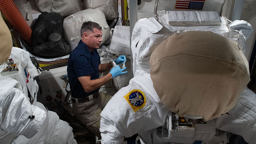 NASA astronaut Shane Kimbrough replaces life support components inside a U.S. spacesuit.