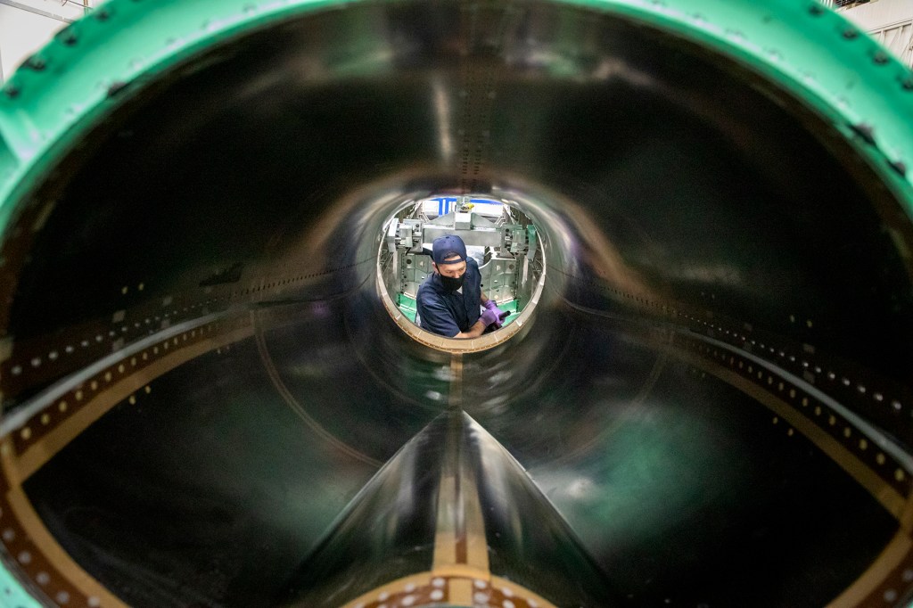 A photo of Lockheed Martin employee completing the final mating of the wing assembly of the SEG 500 Empennage, SEG 400.