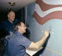 sts_1_postflight_17_mccall_with_bean_painting_astronaut_pin_on_jsc_mural_1979