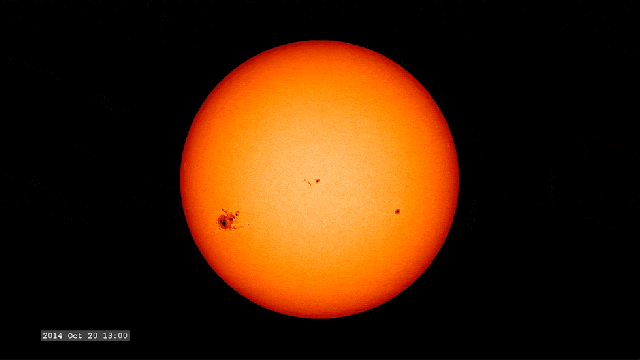 The Sun's surface is dotted with a cluster of dark sunspots