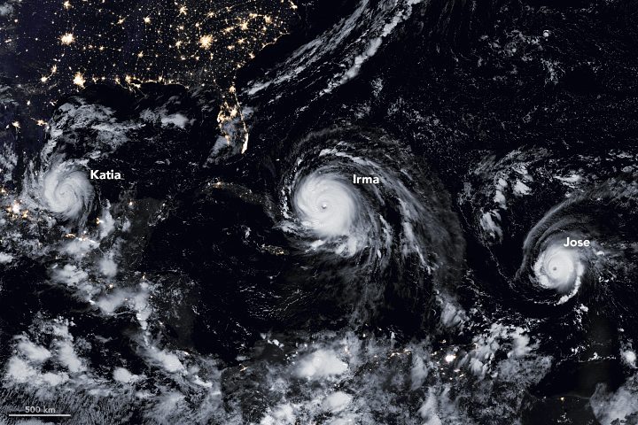Satellite image at night showing cities lights in the southern U.S. at the top of the image and beneath over the Gulf of Mexico three hurricanes in a row: from left to right Katia, Irma, and Jose.