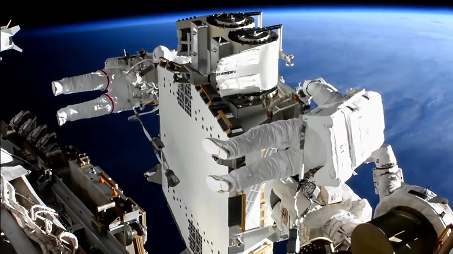 Astronauts Shane Kimbrough, foreground, and Thomas Pesquet work to prepare the second roll-out solar array for installation during an upcoming spacewalk.