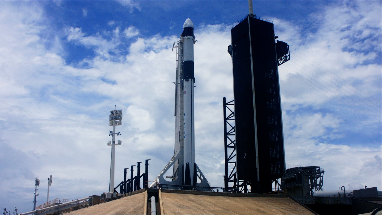 A SpaceX Falcon 9 rocket and Dragon spacecraft stand ready for launch at Launch Complex 39A.