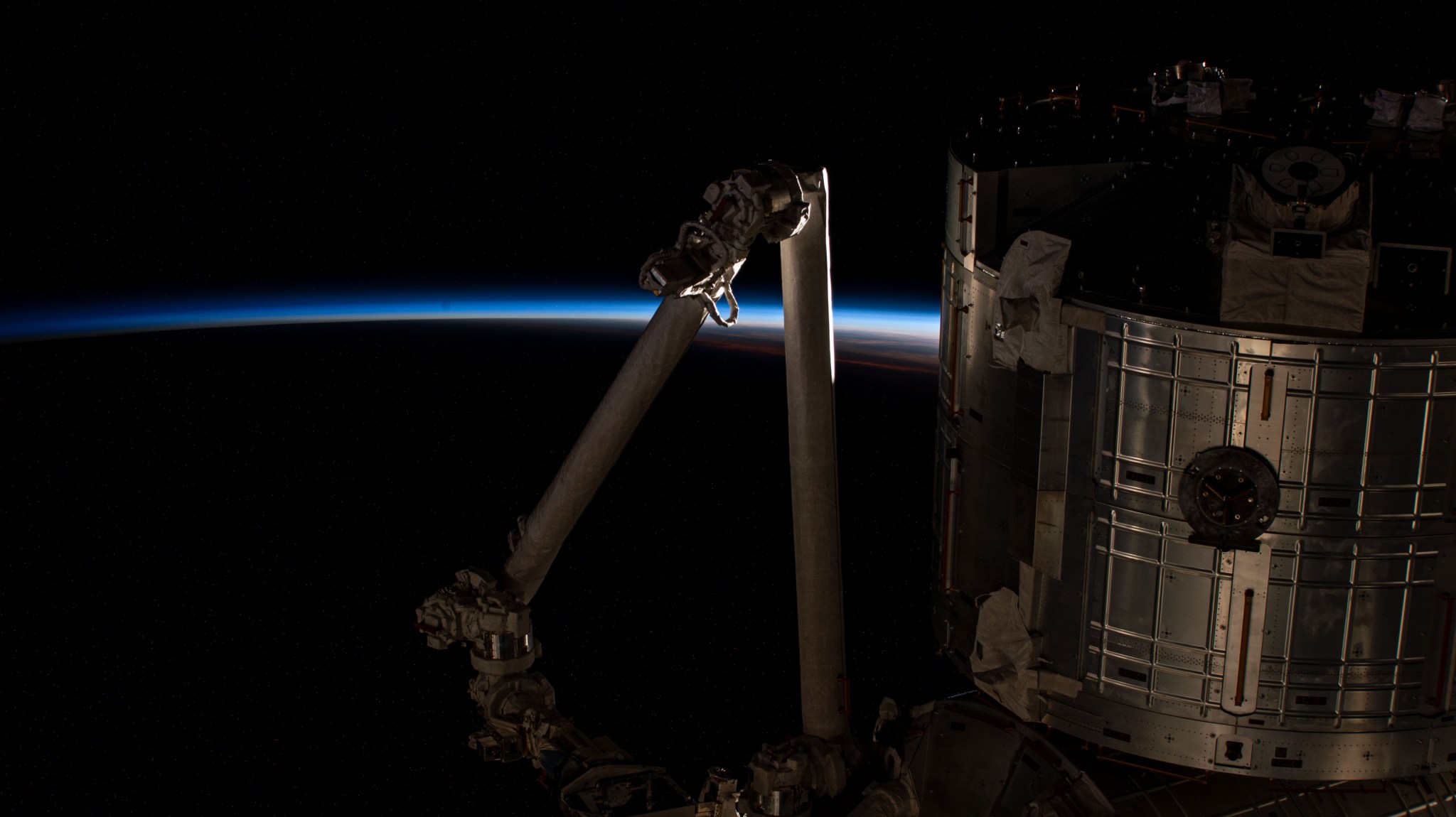 The International Space Station flies into an orbital sunrise