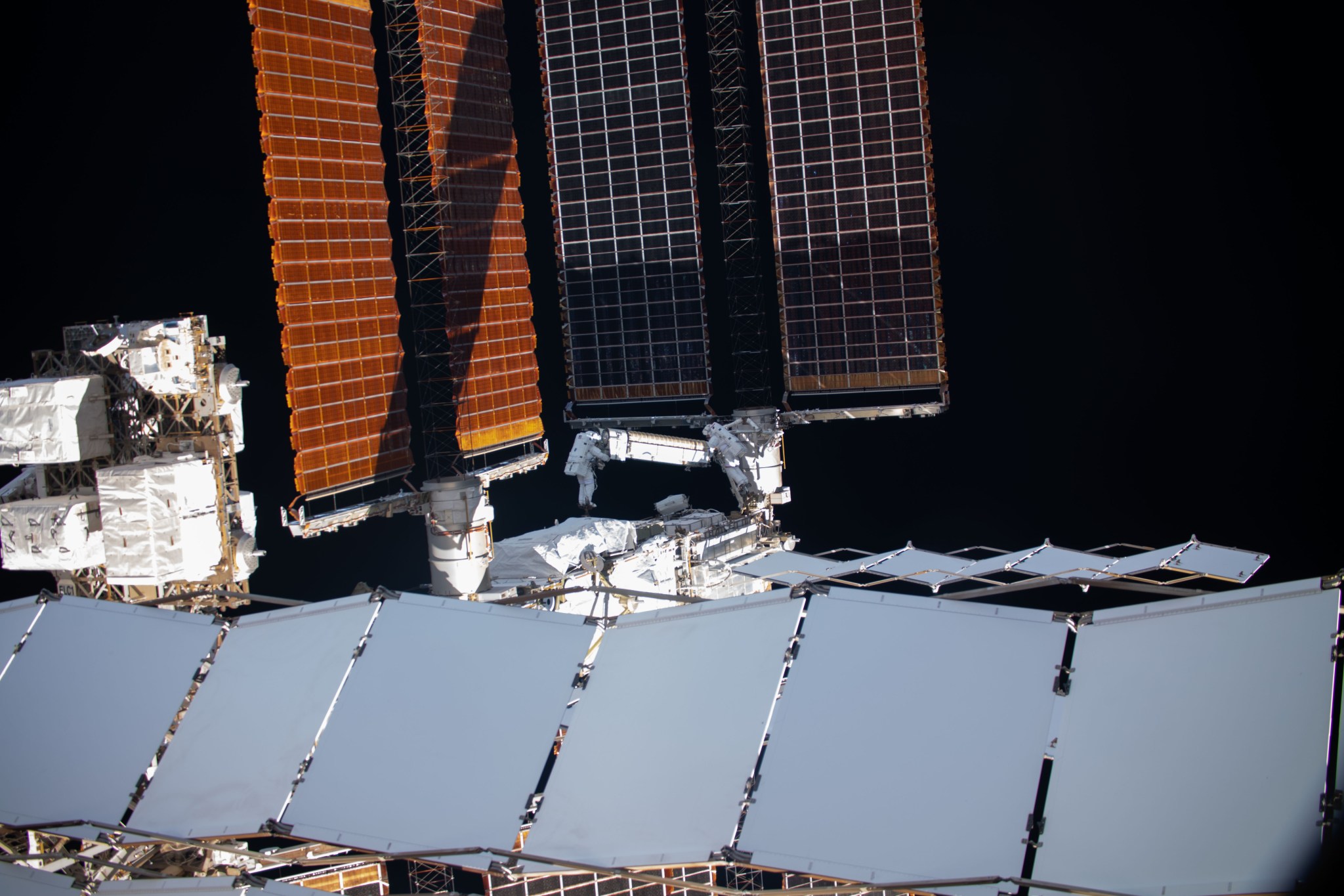 NASA astronaut Shane Kimbrough (left) and ESA (European Space Agency) astronaut Thomas Pesquet maneuver the first ISS Roll-Out Solar Array (iROSA) into place on the space station’s port 6 truss structure during a spacewalk June 16, 2021.