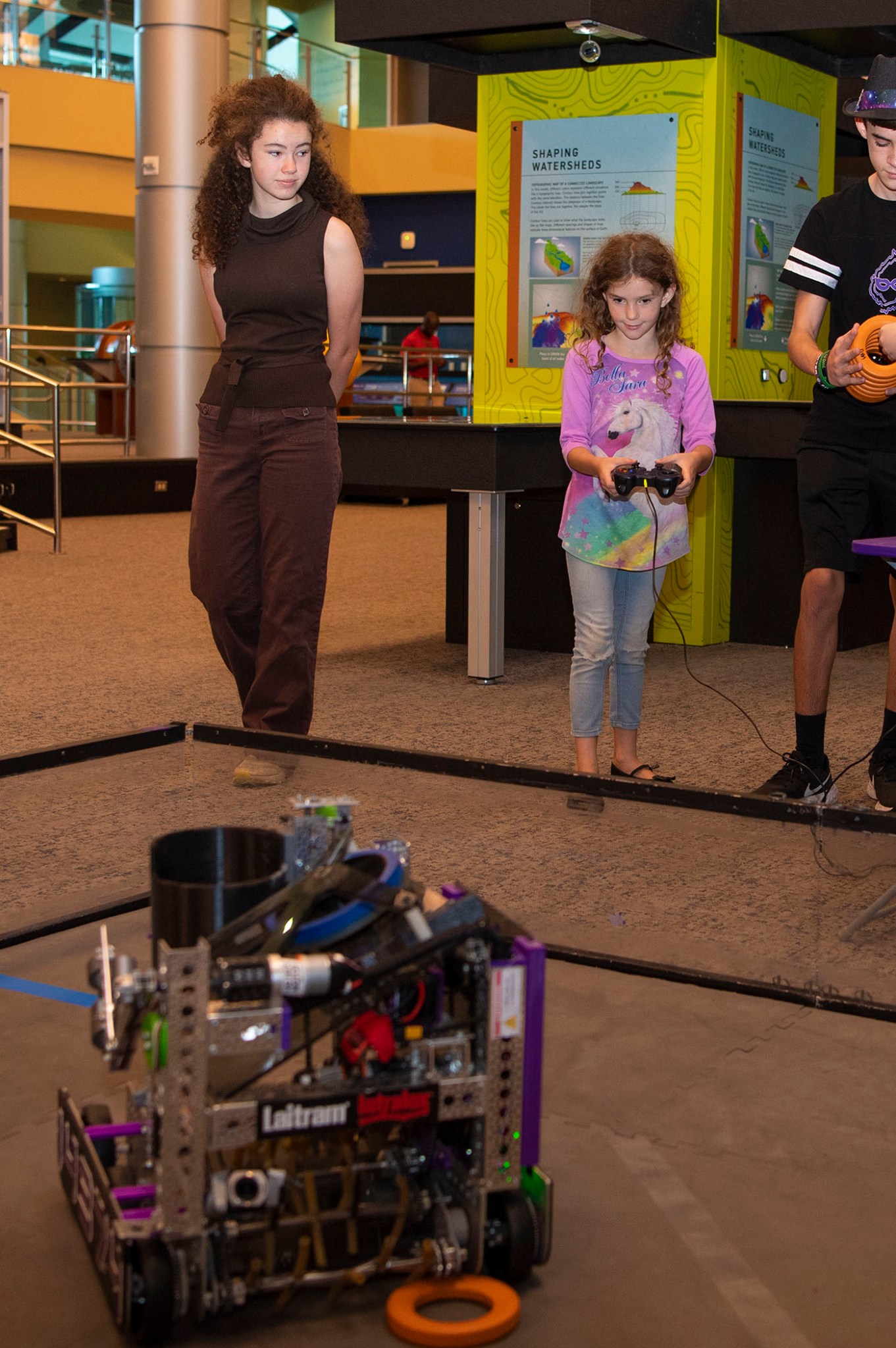A young girl operates a robot, provided by Team 2992