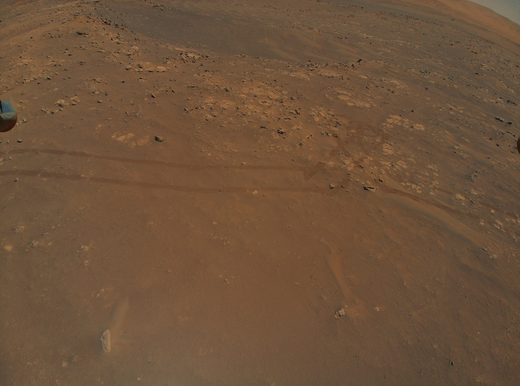 NASA’s Ingenuity Mars Helicopter captured this image of tracks made by the Perseverance rover during its ninth flight, on July 5. A portion of the helicopter’s landing gear can be seen at top left.
