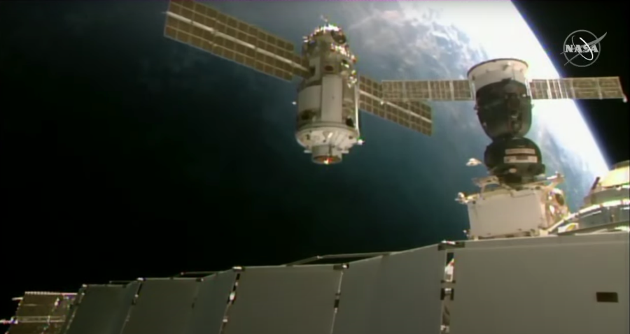new module with solar panels flies near space station with Earth in background