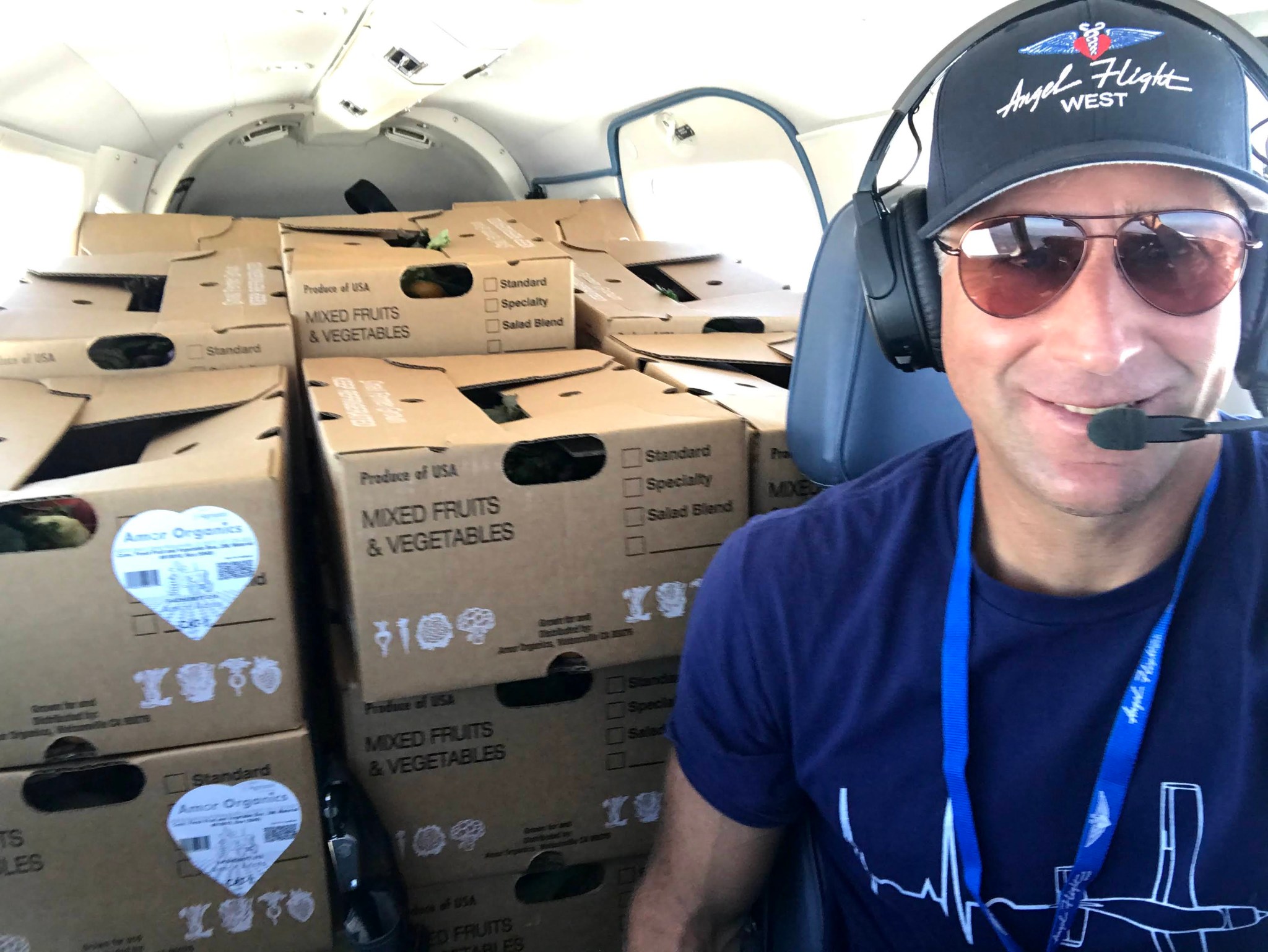 A pilot with Angel Flight West prepares delivery of produce boxes to food banks