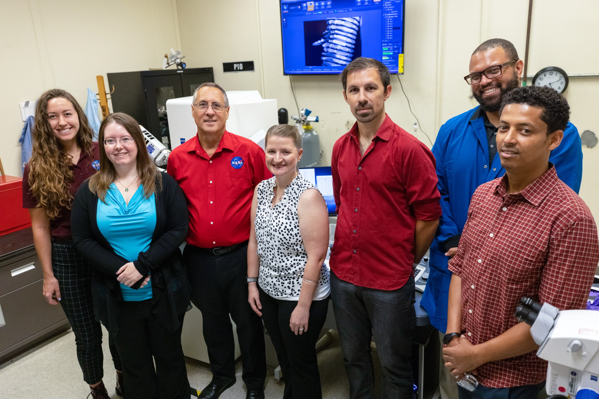 Chemists from NASA Engineering’s Analytical Laboratories at Kennedy Space Center in Florida pose for a photo near a scanning electron microscope on July 7, 2021.