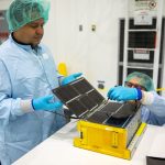 Team Miles works in a clean room at Kennedy to prepare their CubeSat to be launched on the Artemis I mission.