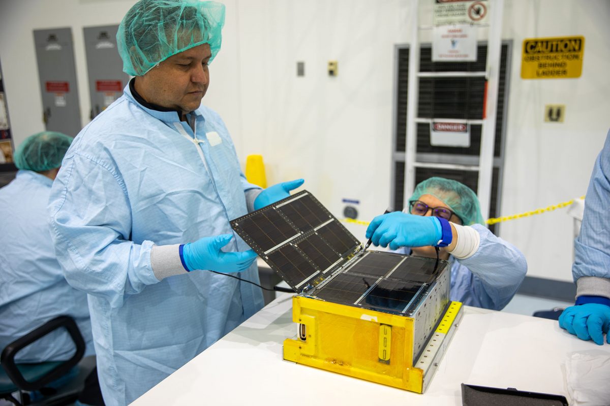 Team Miles works in a clean room at Kennedy to prepare their CubeSat to be launched on the Artemis I mission. 