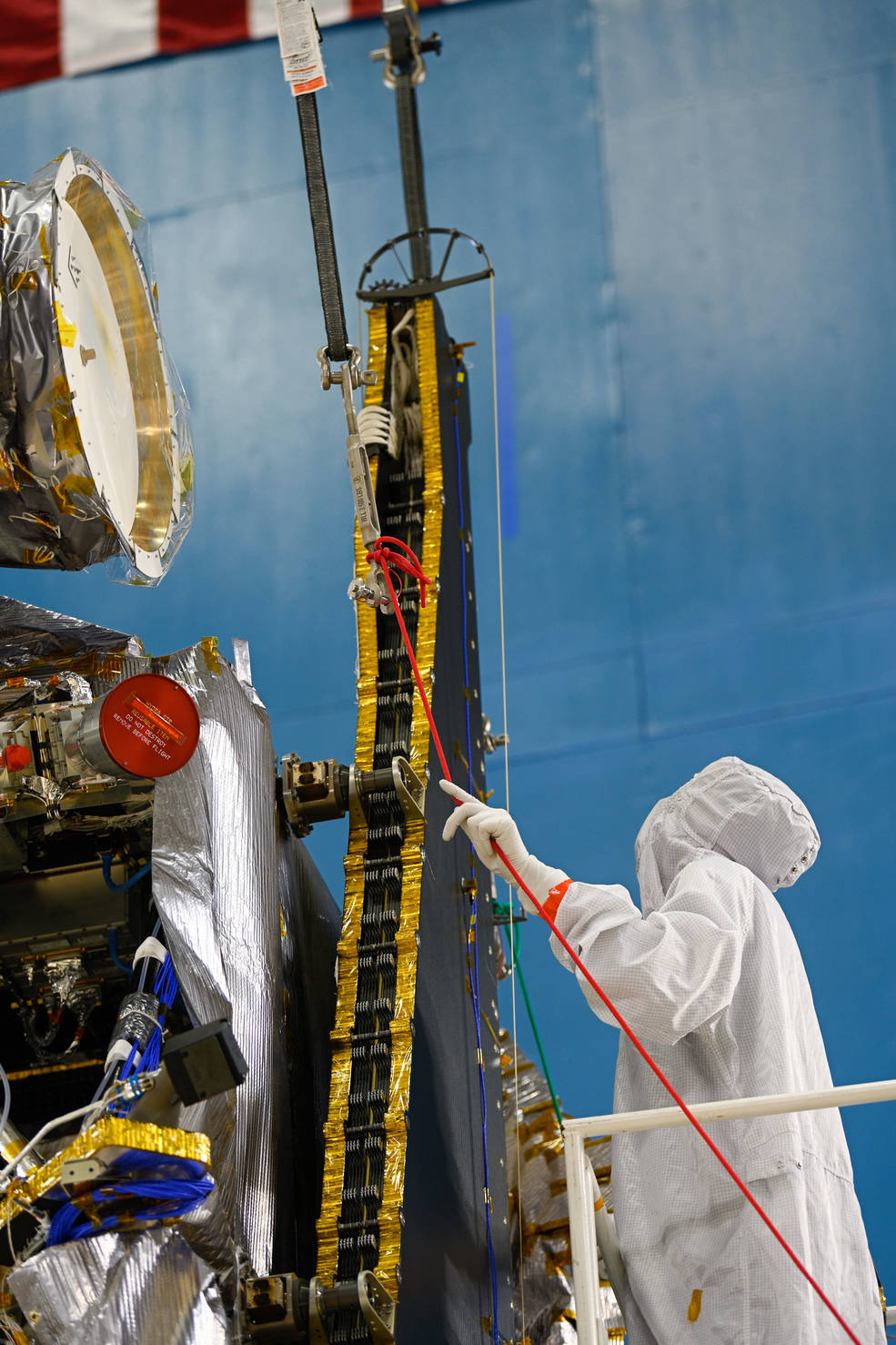 A Lockheed Martin technician makes sure a solar array on NASA's Lucy spacecraft is secured during the Clampband Shock Test in March 2021. T