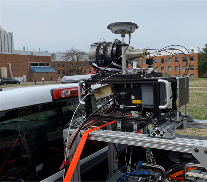 The hazard detection lidar system in the bed of a white truck. The image is zoomed in on the technology. 