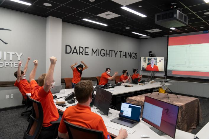 Members of NASA's Ingenuity helicopter team in the Space Flight Operations Facility at NASA's Jet Propulsion Laboratory react to data showing that the helicopter completed its first flight on April 19, 2021.
