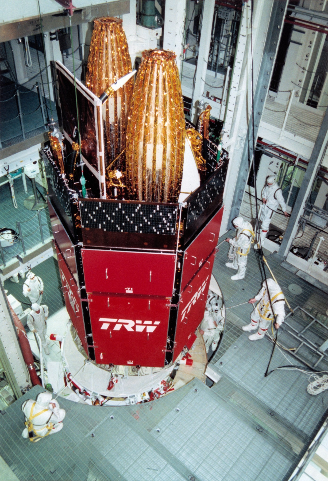 members of the Kennedy’s Payload Processing Team hoist TDRS-G into a work stand in the Vertical Processing Facility.