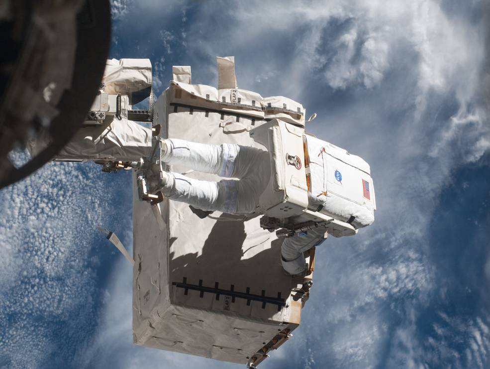 sts_135_9_eva_garan_transferring_pump_module_to_iss